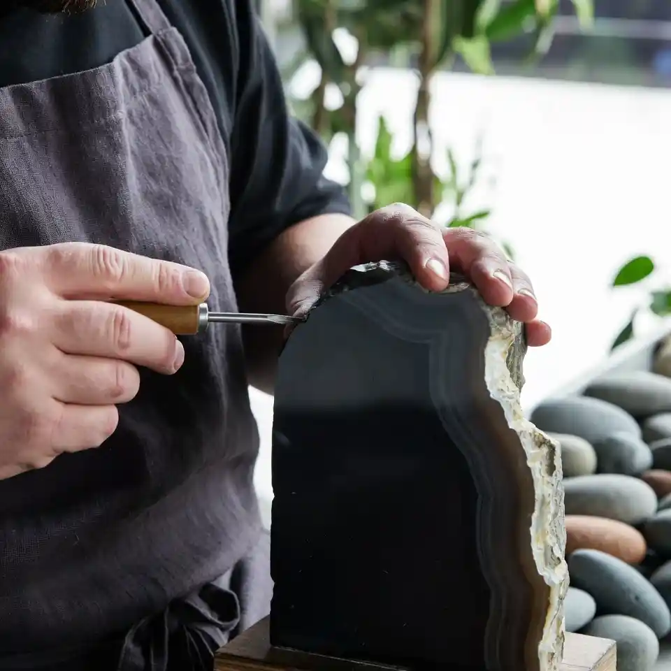Artisan Gemska sculptant à la main une pierre d'onyx noir, savoir-faire traditionnel marocain et artisanat de luxe